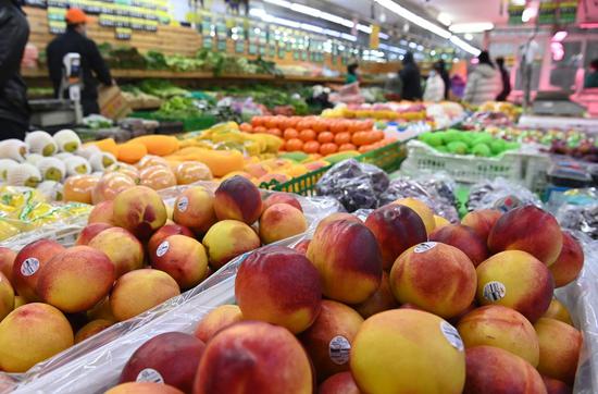 People buy fruits and vegetables at a supermarket in Changchun, northeast China's Jilin Province, March 15, 2022. (Photo by Xu Jiajun/Xinhua)