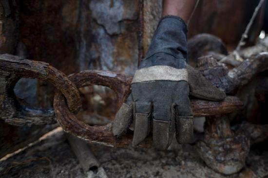 A worker catches a rusty chain at a ship breaking yard in Cilincing of Jakarta, Indonesia, Feb. 13, 2020. Corrosion caused by microbes in marine environment poses a serious challenge for economy and safety. (Xinhua/Agung Kuncahya B.)

