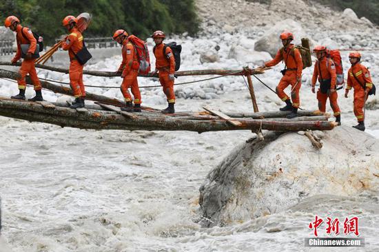 Firefighters pass through a makeshift bridge in Moxi town, Luding, southwest China's Sichuan, Sept. 6, 2022. (Photo/China News Service)