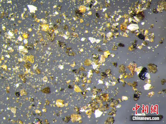 Photo released on Sept. 9, 2022 shows lunar sample brought back by China's Chang'e-5 probe under a microscope. (Photo provided to China News Service) 
