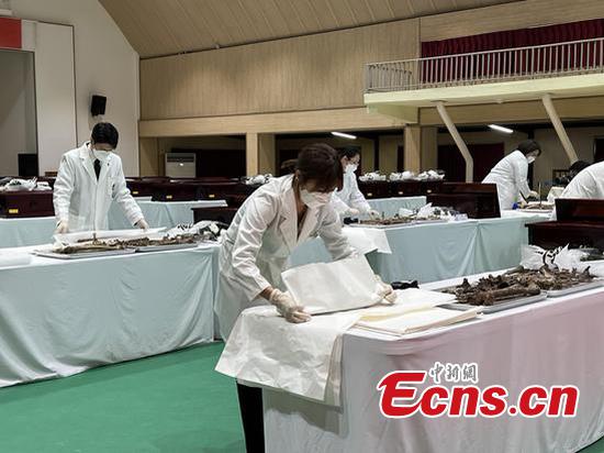 Staff members put the remains of the Chinese People's Volunteers martyrs into coffins in Inchon, the Republic of Korea, Sept. 15, 2022. (Photo/China News Service)