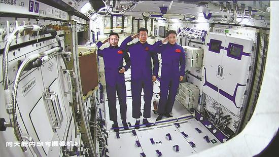 Shenzhou XIV taikonauts Chen Dong (center), Liu Yang (right) and Cai Xuzhe salute after entering the Wentian module, the first lab module of China's space station. (Photo by Xu Bu/For China Daily)