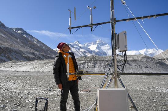 A scientific research member checks an Ozone flux unit at the Mount Qomolangma base camp on May 3, 2022.(Xinhua/Jiang Fan)