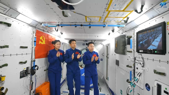 Shenzhou XIV taikonauts Chen Dong (center), Liu Yang (left) and Cai Xuzhe applaud while watching the live broadcast of the opening of the 20th National Congress of the Communist Party of China, Oct 16, 2022. (Photo/China Manned Space Agency)