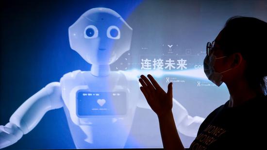 A staff member introduces a promotion video of 5G AI technology at the exhibition center of the national big data (Guizhou) comprehensive pilot zone in southwest China's Guizhou Province, May 26, 2022. (Xinhua/Ou Dongqu)