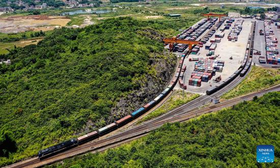 Aerial photo taken on July 29, 2022 shows an outbound freight train at a railway freight center in Wuzhou, south China's Guangxi Zhuang Autonomous Region. Launched in 2017, the New International Land-Sea Trade Corridor is a trade and logistics passage jointly built by western Chinese provinces and ASEAN countries. (Xinhua/Zhang Ailin)
