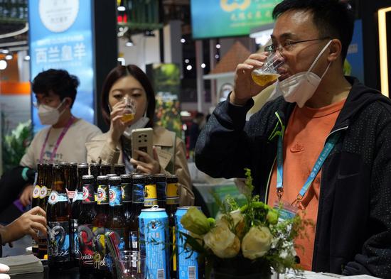 Visitors taste beer at the Food and Agricultural Products exhibition area of the fifth China International Import Expo (CIIE) at the National Exhibition and Convention Center (Shanghai) in east China's Shanghai, Nov. 5, 2022. (Xinhua/Liu Ying)