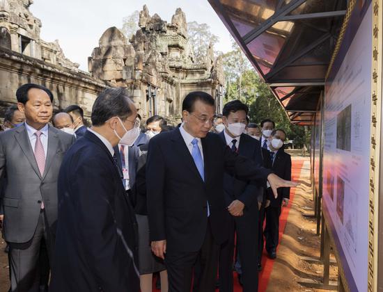 Premier Li Keqiang (center) and Cambodian Deputy Prime Minister Chea Sophara (left) visit an exhibition of achievements in China-Cambodia cultural heritage exchanges and cooperation in Siem Reap, Cambodia, on Thursday. (HUANG JINGWEN/XINHUA)