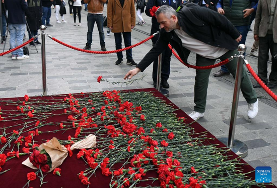 A citizen lays a flower to commemorate the victims of Sunday's terror attack on the Istiklal avenue near Taksim Square in Istanbul, Türkiye, Nov. 14, 2022. The busy avenue was hit by an explosion on Sunday afternoon, killing six and injuring 81. (Xinhua/Shadati)

