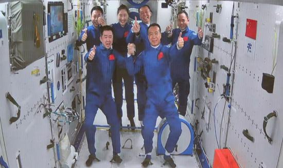 The three astronauts aboard China's Shenzhou XV spaceship meet with another astronaut trio on Nov 30, 2022. (Photo/People's Daily)