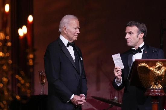 The U.S. president Joe Biden looks at French President Emmanuel Macron at a state dinner on the South Lawn of the White House on December 1, 2022 in Washington, DC. (Photo/Agencies) 
