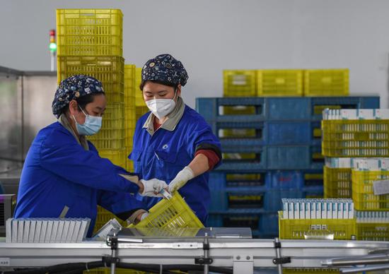 Staff members work at a packaging workshop of a pharmaceutical company in Xi'an, northwest China's Shaanxi Province, Dec. 19, 2022. (Photo by Zou Jingyi/Xinhua)