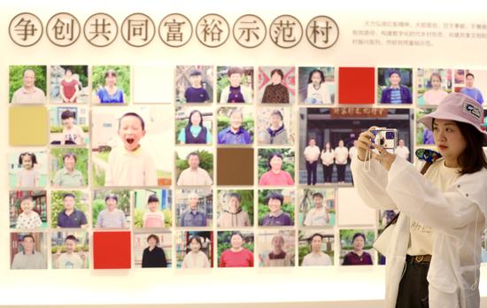 A journalist takes photos at a village history hall in Jiaxing, East China's Zhejiang province, on July 12, 2021. (Photo by Zhu Xingxin/chinadaily.com.cn)