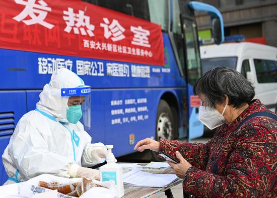 A resident consults a medical worker at a fever clinic in Lianhu district of Xi'an, Northwest China's Shaanxi province, Dec 21, 2022. (Photo/Xinhua)