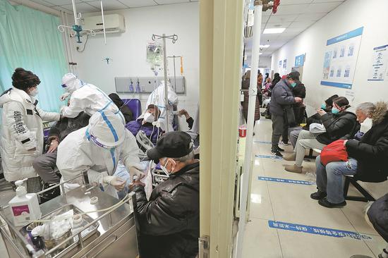 Medical workers run intravenous drips for patients at the fever clinic of China-Japan Friendship hospital in Beijing on Tuesday. (Photo by Wang Jing/China Daily)