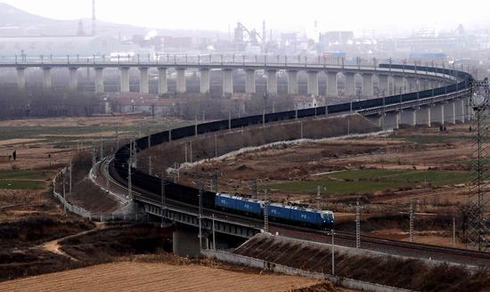 File photo shows a train runs along the Hongqiqu-Shuiye section of Watang-Rizhao Railway in central China's Henan Province, Jan. 15, 2019. (Xinhua/Li An)