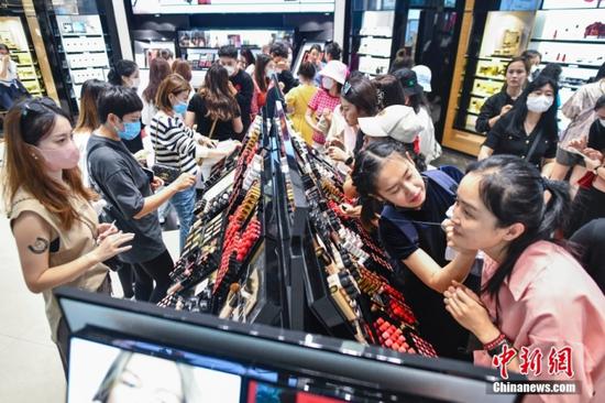 Customers pick cosmetics in a duty-free shop in south China's Hainan, Jan. 22, 2023. (Photo/China News Service)