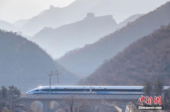 A Fuxing high-speed bullet train passes the Juyongguan Pass of the Great Wall in Beijing, Jan. 6, 2022. (Photo/China News Service) 