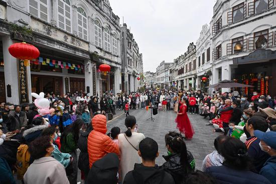 Tourists enjoy performance at the Qilou ancient street during the Spring Festival holiday in Haikou, south China's Hainan Province, Jan. 27, 2023. (Xinhua/Guo Cheng)