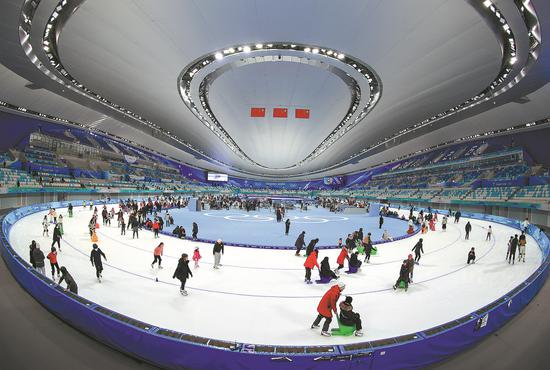 Skaters take to the ice at the National Speed Skating Oval, or Ice Ribbon, in Beijing on Jan 26. Beijing 2022 Winter Olympics organizers are preparing events on Saturday to mark the anniversary of the Games' opening. (Photo: China News Service/JIa Tianyong)