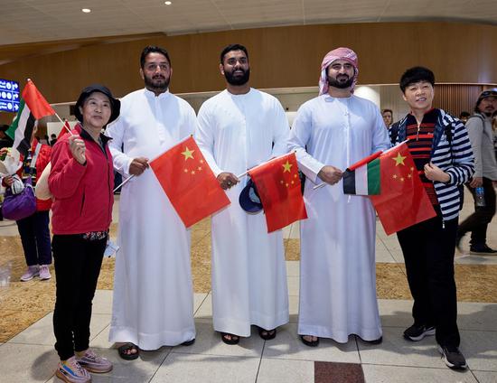 Chinese tourists pose for photos with staff at Dubai International Airport in Dubai, the United Arab Emirates, Feb. 6, 2023. (Xinhua)