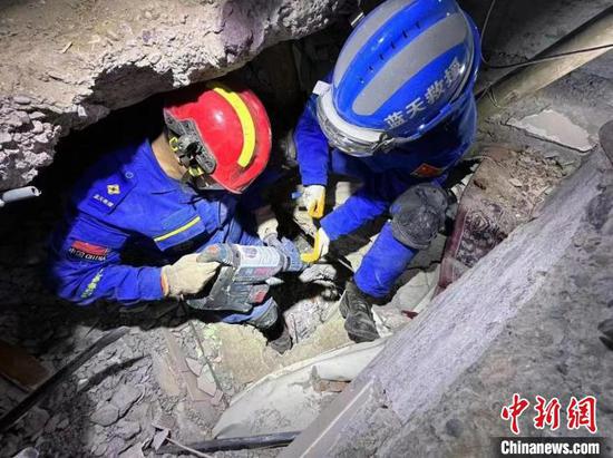 Two members of China's Blue Sky Rescue Team carry out rescue operations in Türkiye. (Photo provided to China News Service )