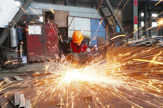 A staff member works at a workshop in an engineering machinery company in Xintian County of Yongzhou City, central China's Hunan Province, Feb. 13, 2023. (Photo by Liu Guixiong/Xinhua)