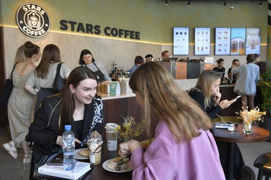 People sit inside the newly-opened Stars Coffee, a chain that opened in former Starbucks coffee shops in Moscow, Russia, Aug. 22, 2022. (Photo by Alexander Zemlianichenko Jr/Xinhua)