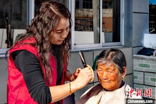 A volunteer cuts hair for a senior. (Photo provided to China News Service)