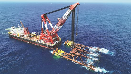 A floating crane helps install marine equipment near the Enping oilfield off the mouth of the Pearl River. (PHOTO by CHEN WEN/CHINA NEWS SERVICE)