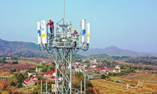 Network maintenance staffers at the local subsidiary of China Mobile in Tongling, East China's Anhui Province test antennas for 5G base stations on December 13, 2021. As of early December, the Tongling subsidiary had built over 650 5G stations, enabling full coverage in Tongling's rural hot spots. (Photo/China News Service)