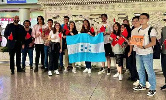 Honduran students who have arrived at the Beijing Capital International Airport pose for a group photo, holding national flags of Honduras and China, on July 4, 2023. (Photo/CCTV)