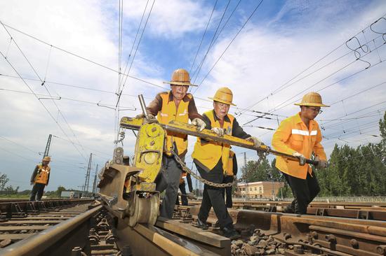 Railway maintenance workers endure extreme heat