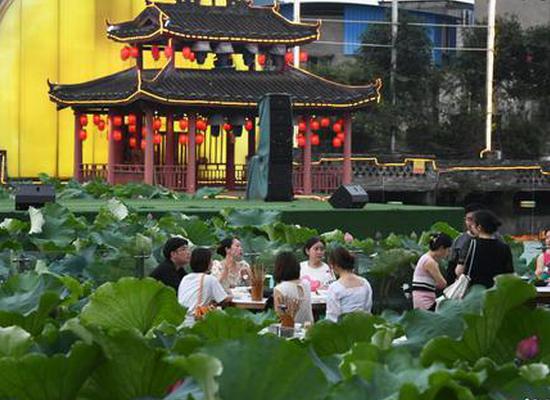 People enjoy hotpot beside lotus pond in Chongqing