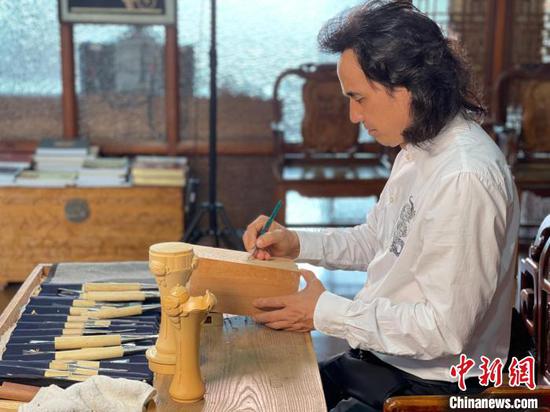 Huang Xiaoming makes the floral vessels for Hangzhou Asian Games. (Photo: China News Service/Lou Yaolin)