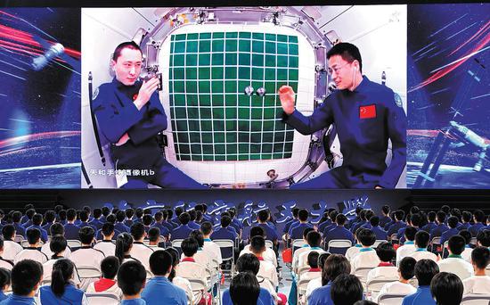 College and school students at Beihang University in Beijing watch Shenzhou XVI crew members conduct a science experiment on Thursday inside Tiangong space station. (Photo by Kuang Linhua / China Daily)