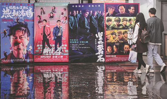 Film fans check out posters promoting the latest blockbusters at a cinema in Shenyang, Liaoning province, on Monday. (ZHANG WENKUI / FOR CHINA DAILY)