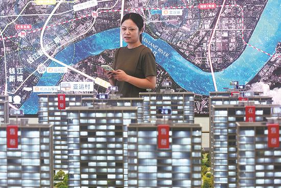A potential homebuyer looks at a property model in Hangzhou, Zhejiang province. (LONG WEI/FOR CHINA DAILY)