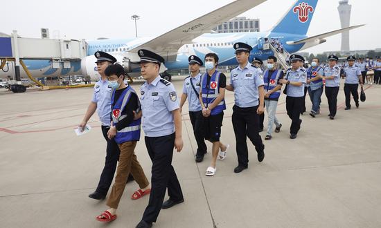 Police officers escort telecommunications fraud suspects from a charted plane arriving from Laos at the Zhengzhou Xinzheng International Airport in Henan Province on September 11, 2023. (Photo: Li Hao/GT)