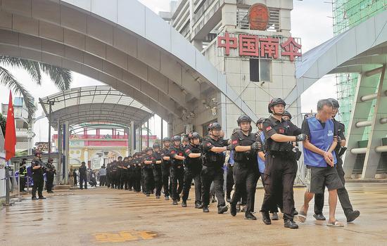 Telecom fraud suspects are handed over to Chinese police in Lincang, Yunnan province. (Photo/China Daily)