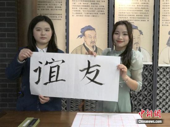 Vietnamese girl Ruan Shifang (R), who is currently studying Tourism Management at Jilin International Students University, wrote two Chinese characters that mean "Friendship". (Photo/China News Service)