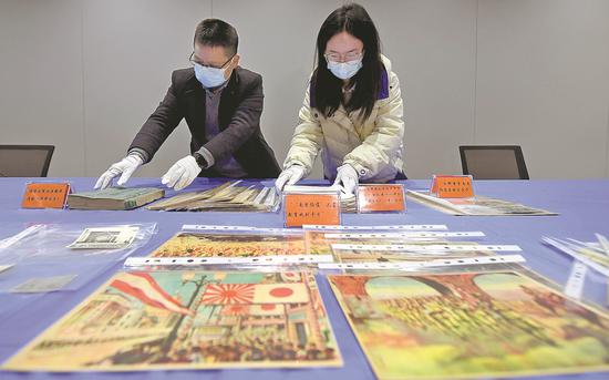 Staff members sort newly collected historical relics at the Memorial Hall for the Victims of the Nanjing Massacre by Japanese Invaders in Nanjing, Jiangsu province, Nov. 30, 2022. (Photo by Wan Chengpeng/For chinadaily.com.cn)