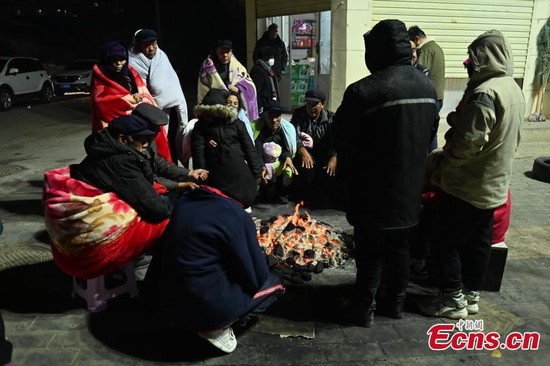 Residents gather around a fire to keep warm on a street after a 6.2-magnitude earthquake hit Jishishan County, northwest China's Gansu Province, Dec. 18, 2023. (Photo: China News Service/Li Yalong)