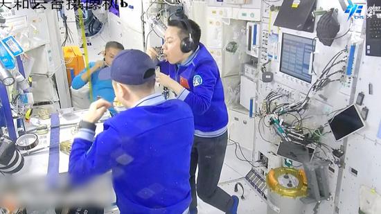 The Shenzhou-17 crew of three taikonauts eat in the China Space Station. （Photo/CMSA)