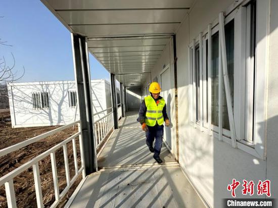 A worker checks a newly built temporary house at