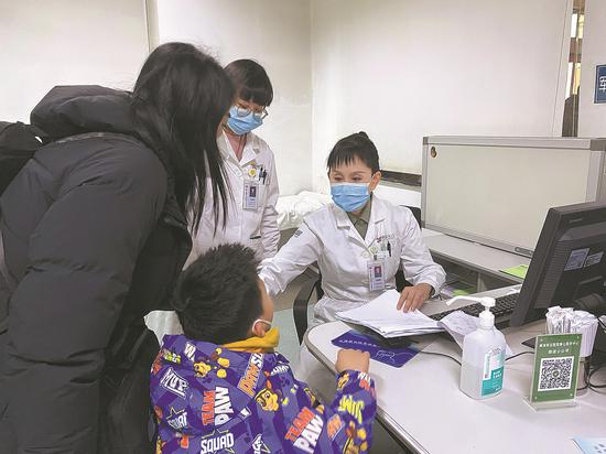 Zhou Huixia, director of the children's medical center at the PLA General Hospital's Seventh Medical Center, checks a patient. (Photo/China Daily)