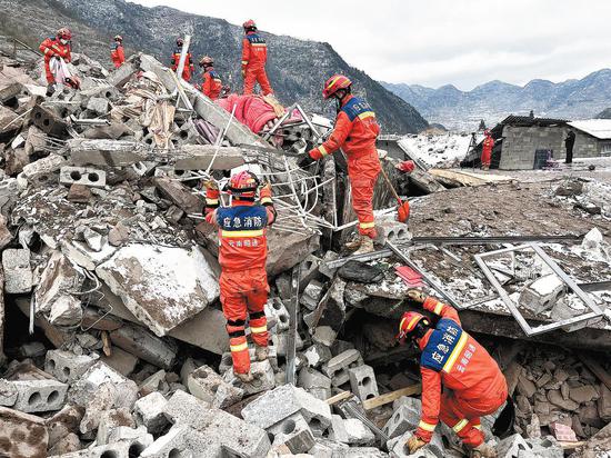 Rescuers hunt for the missing after a landslide buried 47 people in Yunnan province on Monday. Hundreds of rescuers have joined the operation with the help of 174 vehicles. (Photo by Wang jiao / For China Daily)