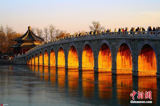 The Seventeen-Arch Bridge, or the Shiqidong Bridge, a popular tourist spot in the Summer Palace, bathed in winter sunset in Beijing. (Photo/IC)