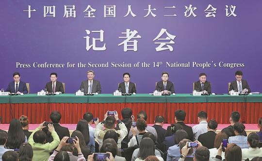 
Reporters take photos at a news conference on the economy during the second session of the 14th National People's Congress in Beijing on Wednesday. (FENG YONGBIN/CHINA DAILY)
