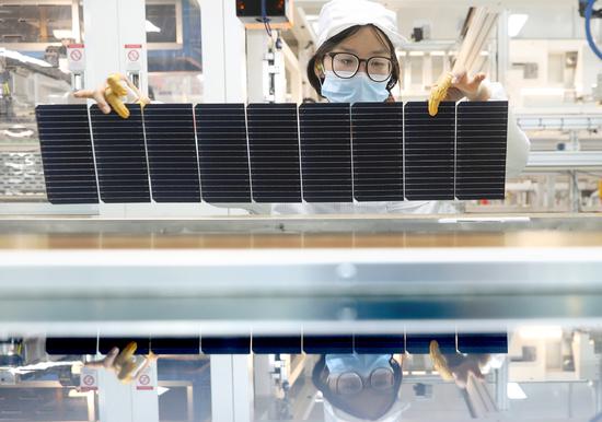 An employee works at a PV panel production facility in Lianyungang, Jiangsu province, on Jan 4. (SI WEI/FOR CHINA DAILY)